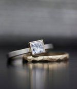 a white diamond ring sitting on top of a table