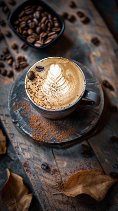 a cappuccino on a plate with coffee beans and leaves around the cup