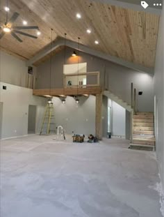 the inside of a house being remodeled with wood ceiling and exposed beams, including stairs