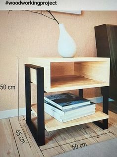 a table with some books on it and a vase sitting next to the end shelf