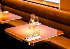 two tables with wine glasses on them in a restaurant