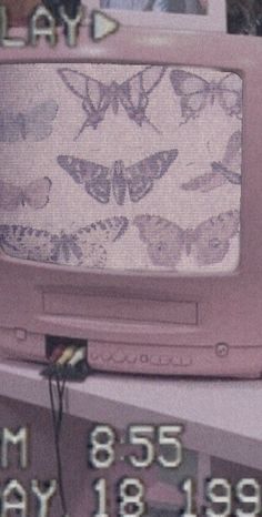 an old pink tv sitting on top of a shelf next to a wall with butterflies drawn on it