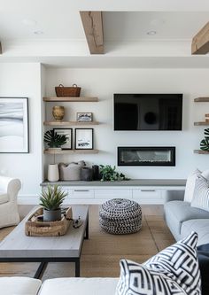 a living room filled with furniture and a flat screen tv mounted on the wall over a fireplace