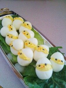 some kind of food that looks like eggs with chicks in them on top of leaves