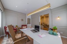 a laptop computer sitting on top of a white desk