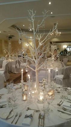 a white table topped with lots of tables covered in white cloths and silverware