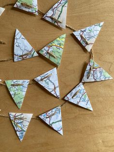 some paper airplanes are hanging on a wooden table with twine and string attached to them