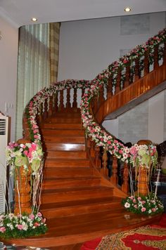 a staircase decorated with flowers and greenery for a wedding or special occasion in the house