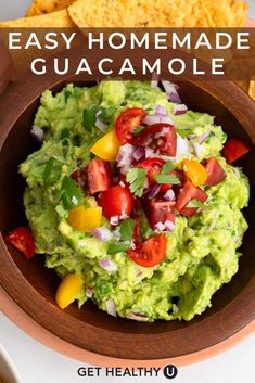 a bowl filled with guacamole next to tortilla chips and salsa