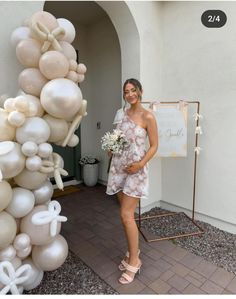 a woman standing next to a bunch of balloons