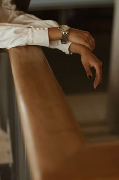 a person sitting on a bench with their hand resting on the edge of the bench