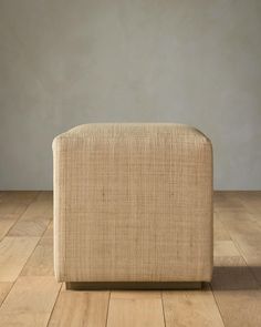 a beige couch sitting on top of a wooden floor