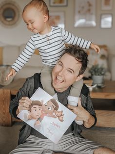 a man holding a baby up to his face while sitting on top of another man's shoulders