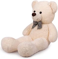 a white teddy bear with a bow on its neck sitting in front of a white background