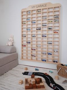 a toy car garage is on the floor next to a couch