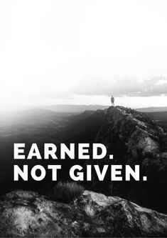 a man standing on top of a mountain with the words earned not given above him