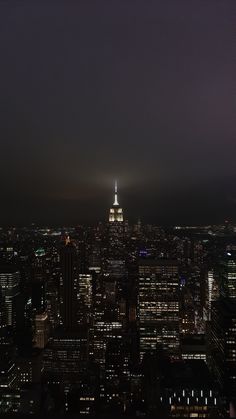 the empire building is lit up at night in new york's cityscape