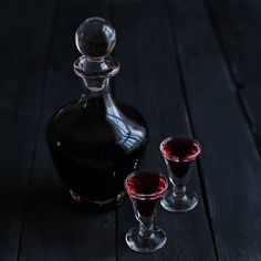 an empty bottle and two glasses on a wooden table