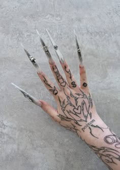 a person's hand with tattoos on it and nails sticking out of the palm