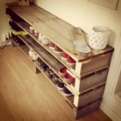 a bench made out of wooden pallets with many different colored pots on top of it