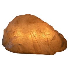 a rock shaped like a human head with light shining on it's face and body