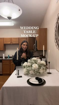 a woman sitting at a table with flowers and candles