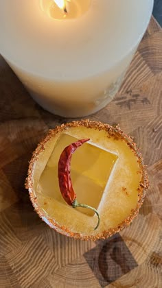 a candle is next to a small bowl with food in it