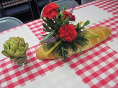 the table is set with red and white checkered cloths, vases filled with flowers