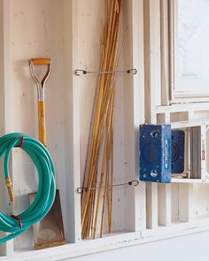 there are some gardening tools hanging on the wall next to each other in this room