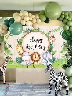 an animal themed birthday party with balloons and jungle animals, including zebras and giraffes