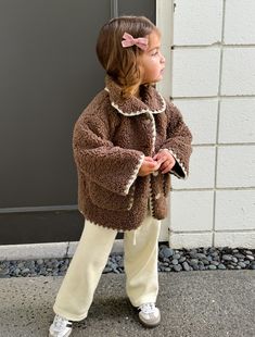 Our bestseller that keeps selling out! Features a blanket stitch detail around collar, pockets, sleeves and bottom of the coat. Fit is oversized and can be worn over layers. Drop shoulder and slight bell at the sleeves. The lining is self and is the backside of the faux sherpa fleece fabric. Functional button closures. We recommend taking your child's normal size in this jacket. *Model is 2.5 years old and is wearing the size 2Y