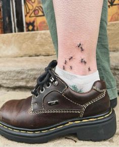 a person wearing brown shoes with black bees on their ankles and feet, while they are standing next to each other