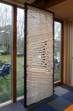 a room with large sliding glass doors that have wavy designs on the outside and inside