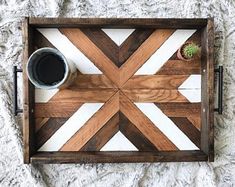 a wooden tray with a coffee cup on it and a succulent plant in the middle