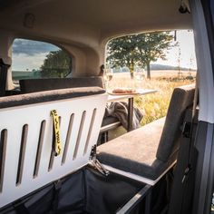 the interior of a camper van with two seats and a table in the back