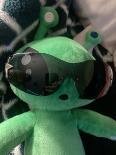 a green stuffed animal with goggles on it's head