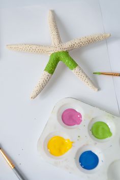 the starfish is next to some paints and a paintbrush on top of it