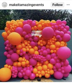 an orange and pink balloon wall with lots of balloons