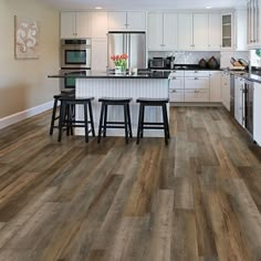 a kitchen with wood flooring and white cabinets