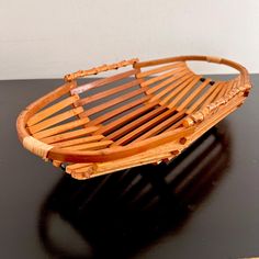 a wooden basket sitting on top of a black table