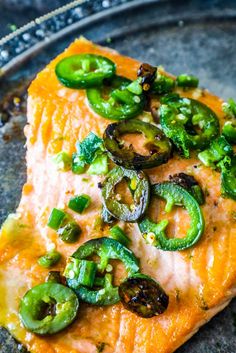 a piece of salmon topped with green peppers and jalapenos on a plate