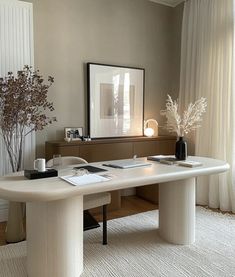 a white desk with two vases on it in front of a window and curtains