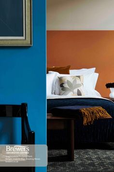 a bed sitting next to a blue wall in a bedroom