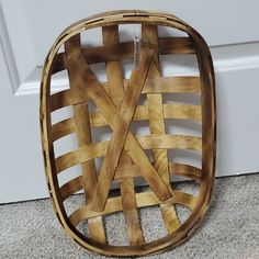 a wooden basket sitting on the floor next to a door