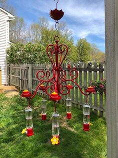 a red chandelier hanging from the side of a fence