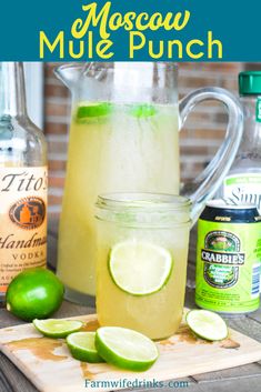 a pitcher filled with lemonade and limes next to two bottles of mojito mule punch