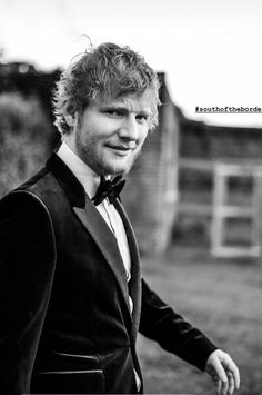 a black and white photo of a man in a tuxedo posing for the camera