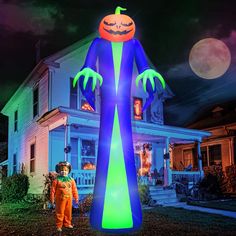 a large inflatable halloween decoration with an orange and green pumpkin on it's head