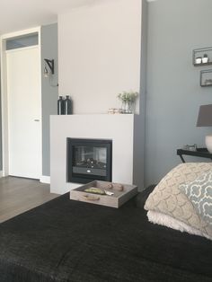 a living room with a fire place in the center and a black rug on the floor