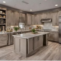 a large kitchen with stainless steel appliances and wooden floors